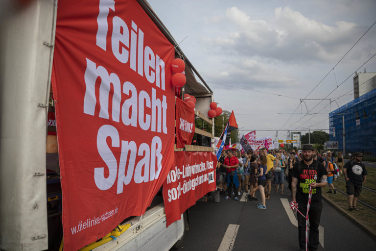 Ein Banner mit der Aufschrift "Teilen macht Spaß", befestigt an einem Demo-Lauti